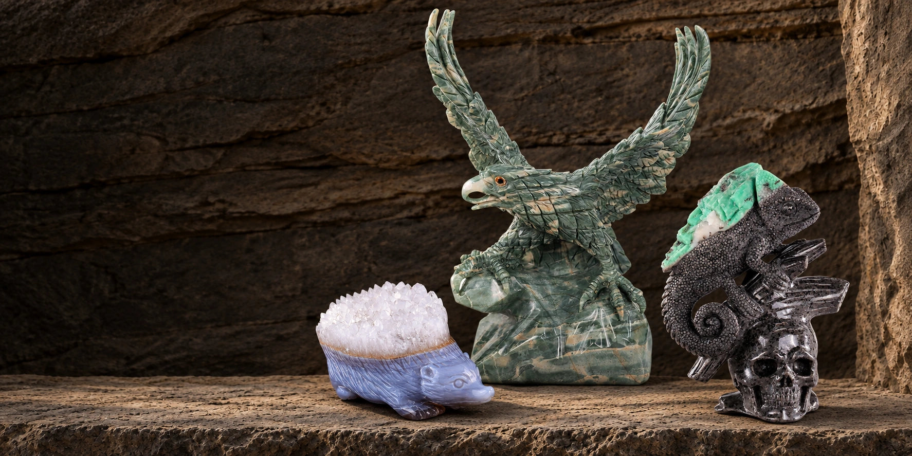 Jade eagle, quartz hedgehog and emerald lizard carvings on a stone shelf